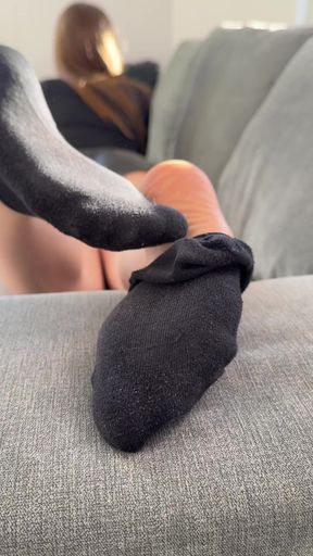 Couple sits comfortably removing their stinky socks