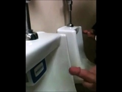 two slim dicks getting wanked at the urinals