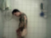 Homme bi et tattoué prend une longue douche chaude