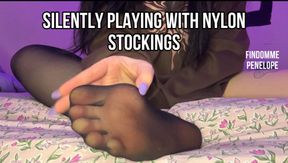 Silently playing with nylon stockings, taking them off and putting them on again. Playing with feet