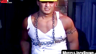 MuscleJockBound.com - Bound by chains, tattooed man in uniform endures rough and erot