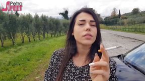 Outdoors smoking cigar from sexy brunette