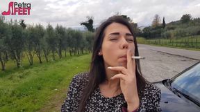 Outdoors smoking cigar from sexy brunette