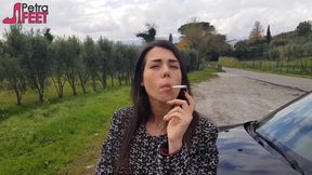 Outdoors smoking cigar from sexy brunette