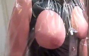 Crossdresser spielt mit seiner Frau in Plastik und PVC