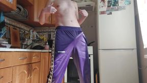 A Russian dude in sweatpants drains off in the kitchen.