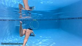Carissa in her pool in a fuchsia micro bikini swimming and playing a ring game