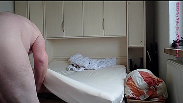 Nackter Nylonjunge bezieht sein Bett