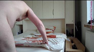 Nackter Nylonjunge bezieht sein Bett