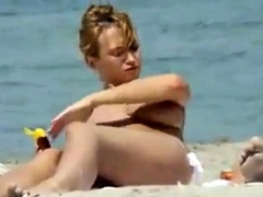 Oiling boobs on topless beach