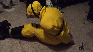 Self-bondage in yellow pvc rainsuit
