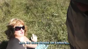 Perverse man trekt een sexy blondine naakt in de zon op het strand.
