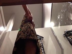 Blonde babe tries on summer dresses in a dressing room