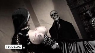 Een sexy vampier-cosplayer laat kaarsvet op haar enorme borsten druppelen.