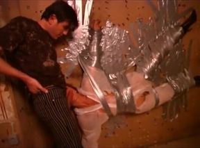 Dominus Ronaldo taped his redheaded slave to the wall and lets her suck him in that position