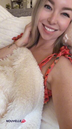 Smiling woman in bed with teddy bear