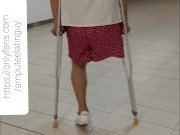 Amputee guy walking around with crutches