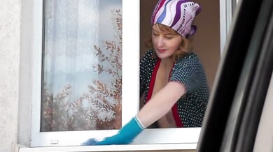 Blonde in black stockings cleans window then strips topless for exhibitionist show