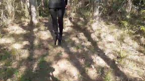 Walking on the wood wearing a black dress, pantyhose and high heels ankle boots