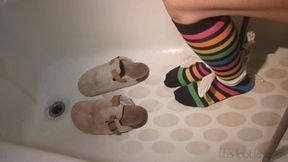 Fifi in ankle socks tied to a stool in the bathtub with cold water rising