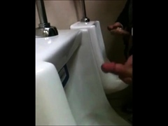 two slim dicks getting wanked at the urinals