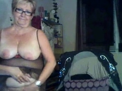 Vieille joue avec ses seins et se doigte la chatte