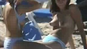 A brunette couple of sexy teen chicks half naked on the beach