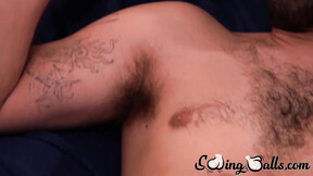 Bushy gay with shaved balls strokes dick while watching porn