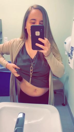Woman taking selfie in bathroom mirror