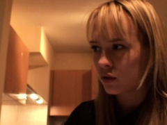 Blonde is watching an old party on her computer and makes something to eat