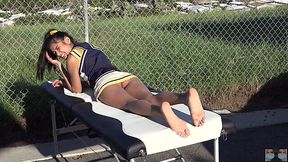 Cheerleader without panties sunbathing on the massage table