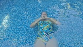 Mermaid tries to make silly faces underwater