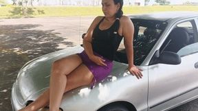 Woman crossing her legs while sitting in the front of her car like a model (3)