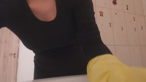 Indian stepsister washes dishes in a yellow glove and plays with the white foam on the glove