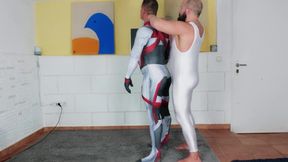 Muscle man tries on spandex cosplay suit with the help of his muscle Daddy