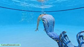 Carissa in the mermaid tail swimming and blowing bubbles in the pool