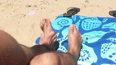 Kinky lad is filming his feet while chilling on the beach