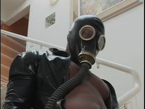 Two guys wearing masks get their large cocks sucked by a hot chick in latex gear