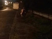 Nude on roadside beside campervan