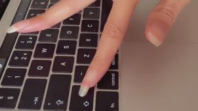 Miss October taps and scratches on her keyboard with long, natural nails