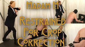 Restrained For Crop Correction, Strapped securely into a punishment bench, a helpless submissive endures a prolonged dressage crop correction session as Madam M tests obedience, endurance, and self-control.
