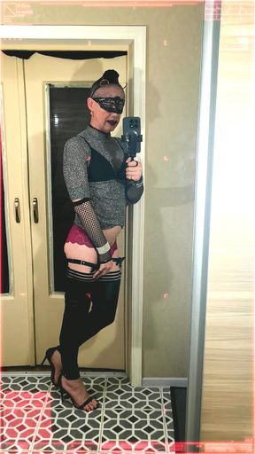 A young femboy films herself in the mirror stroking her clitoris in red panties, high heels, a mask, and ears.