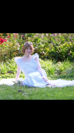 Girl in white dress sitting on grass
