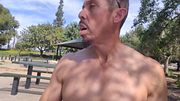 naked man mocks public bench with cock thrust