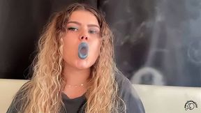 Exotic goddess with wild hair blows smoke for you