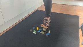 Raven Lee crushing tiny plastic cars and vans in sexy wedges with painted toenails high view