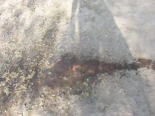 A MILF piss, while walking behind the garages on the street and in the yard. Urine from under her bald cunt.