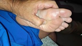 Giving her  a soft foot rub and massage on the couch
