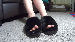 Toe wiggling in plush black slippers TS