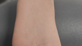 Xin Xin lays on the sofa while playing on her phone and her soles exposed